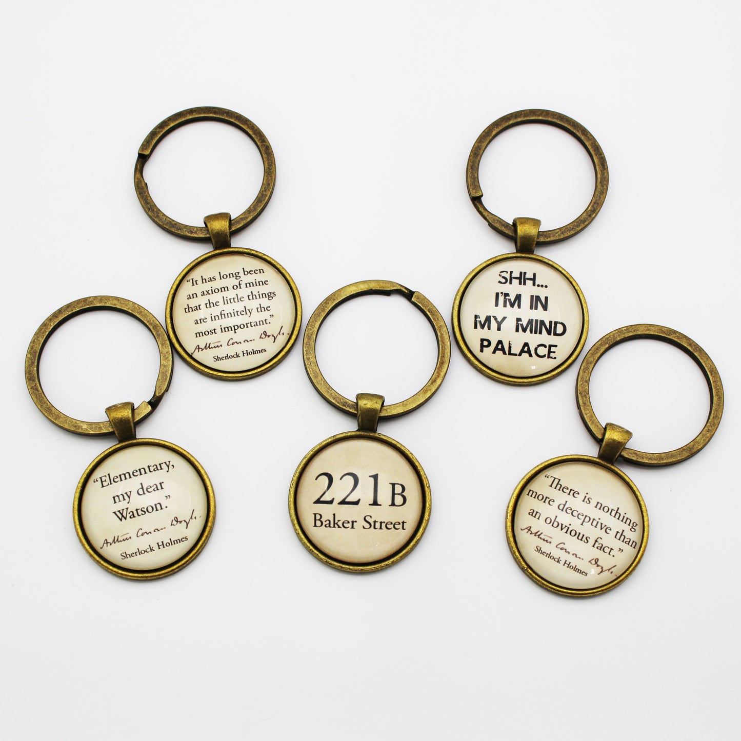 Set of keyrings with Sherlock Holmes quotes on a white background