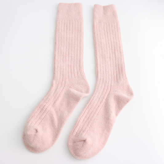 Pair of pink winter socks on a light grey background