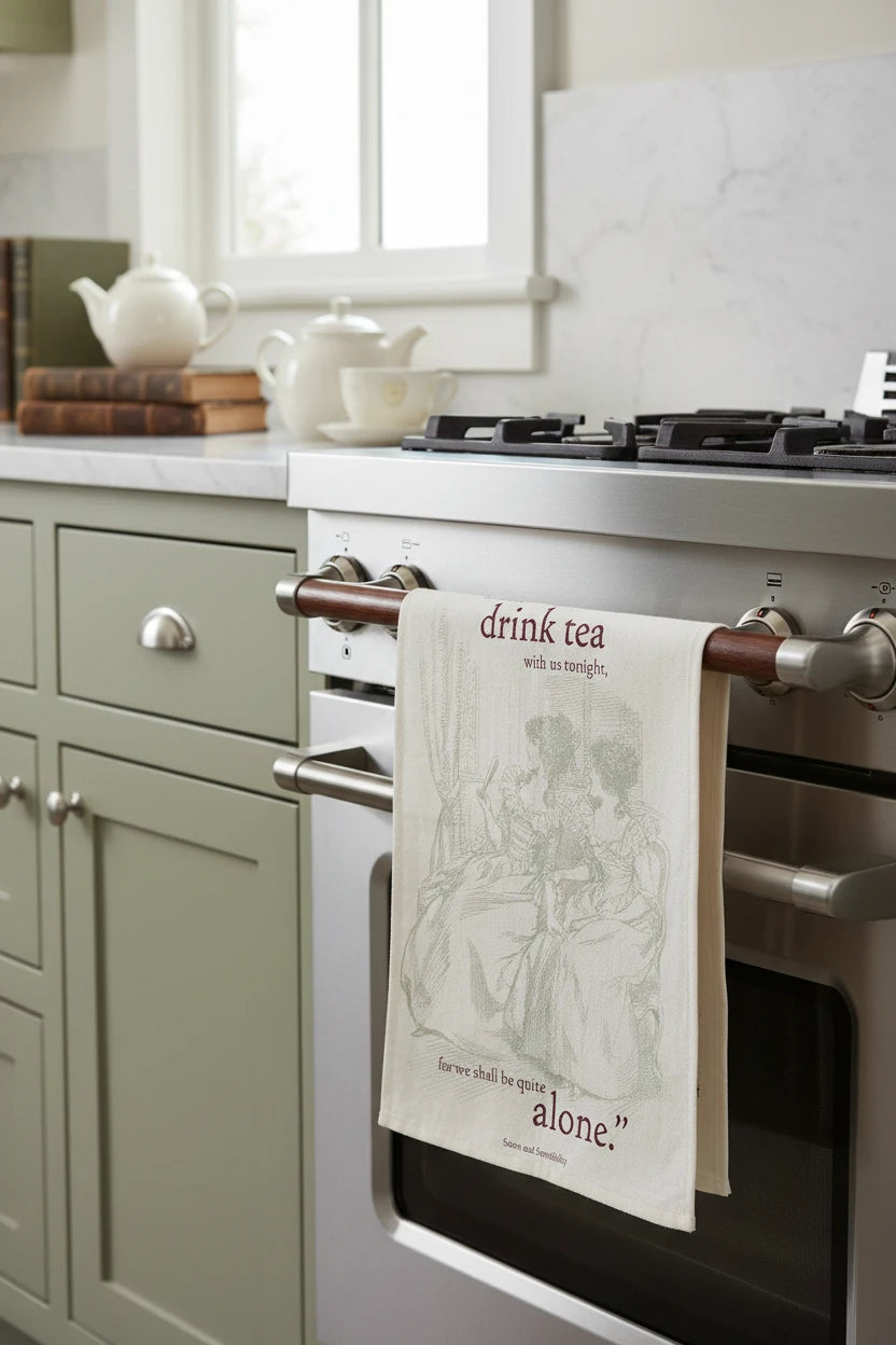 Tea towel with illustration of two women and text about drinking tea, on a white background
