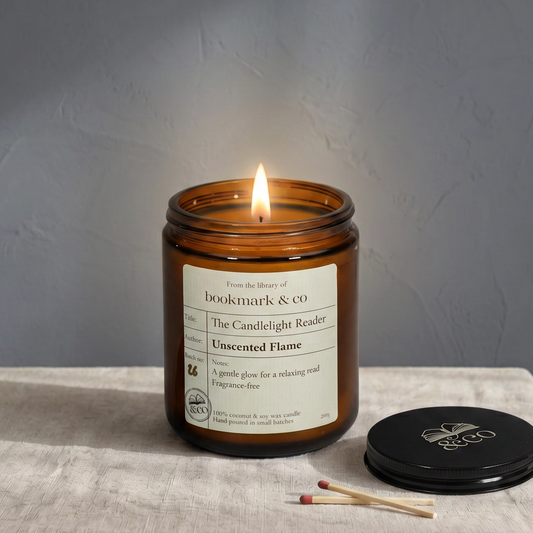 Candle in an amber jar with a label on a textured surface against a gray background