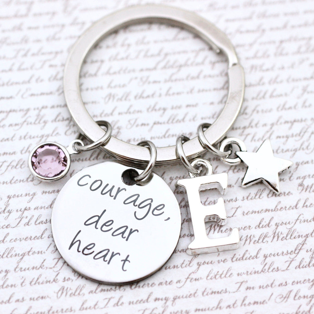 Keychain with 'Courage dear heart' tag and charm on a text background
