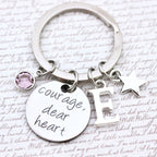 Keychain with 'Courage dear heart' tag and charm on a text background