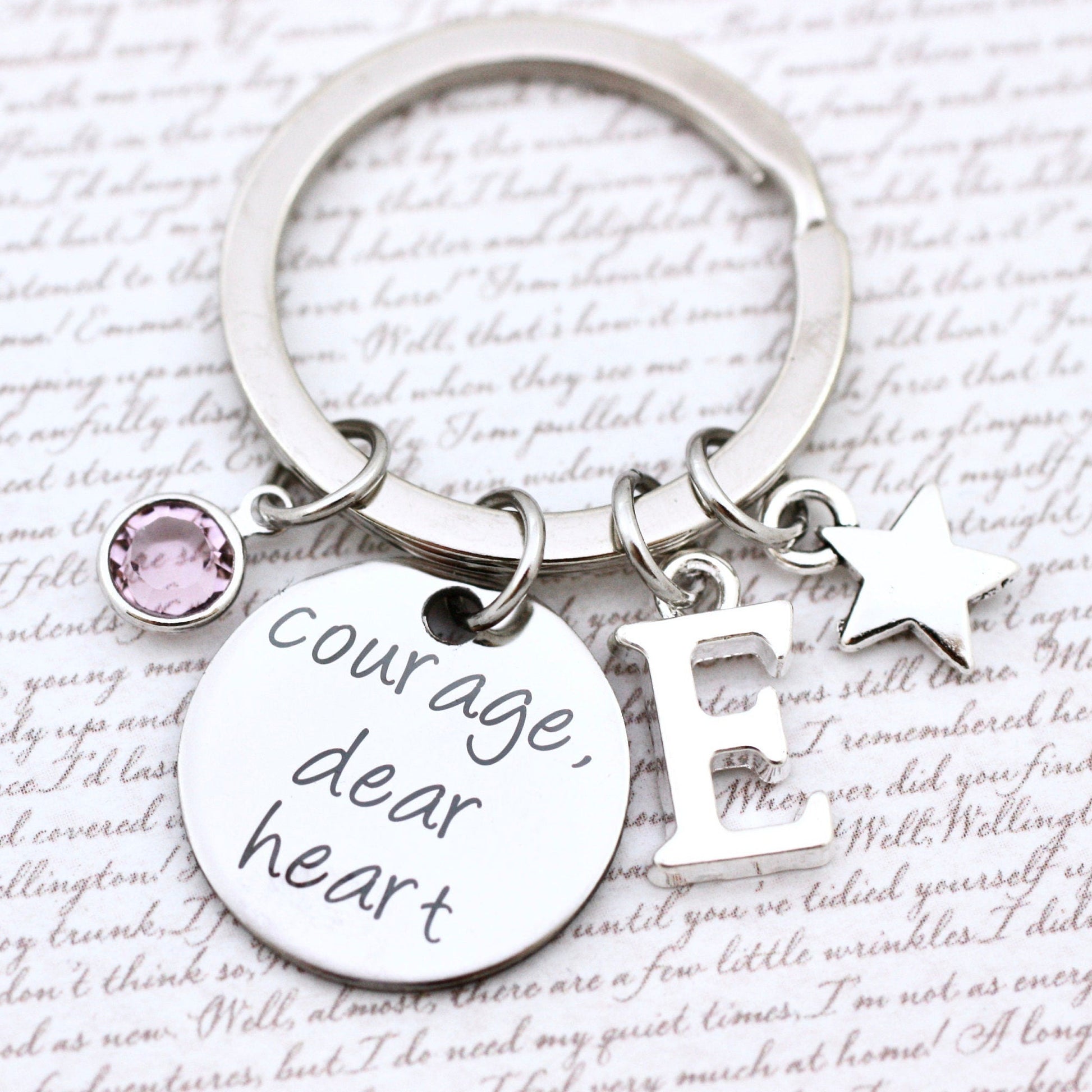 Keychain with 'Courage dear heart' tag and charm on a text background