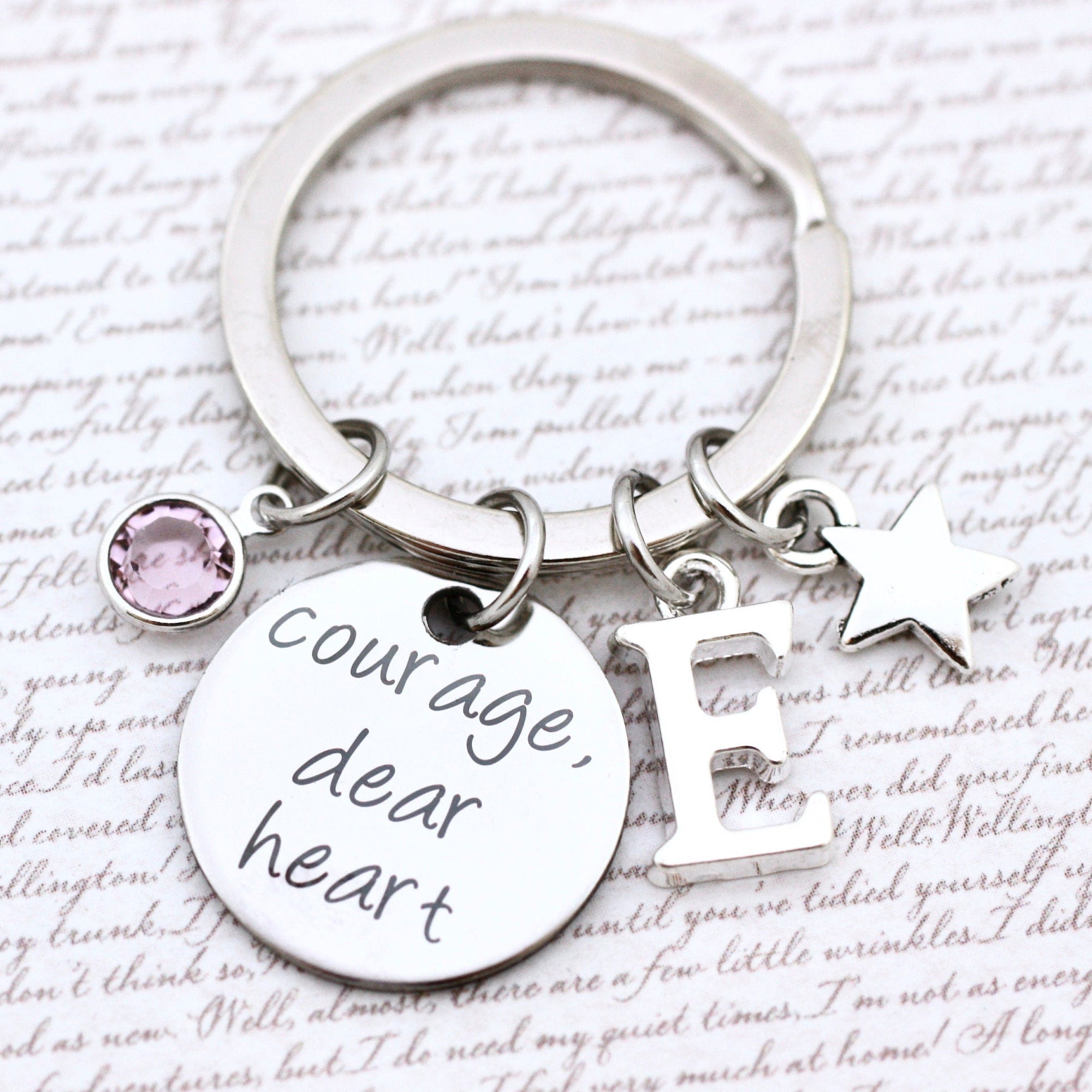 Keychain with 'Courage dear heart' tag and charm on a text background