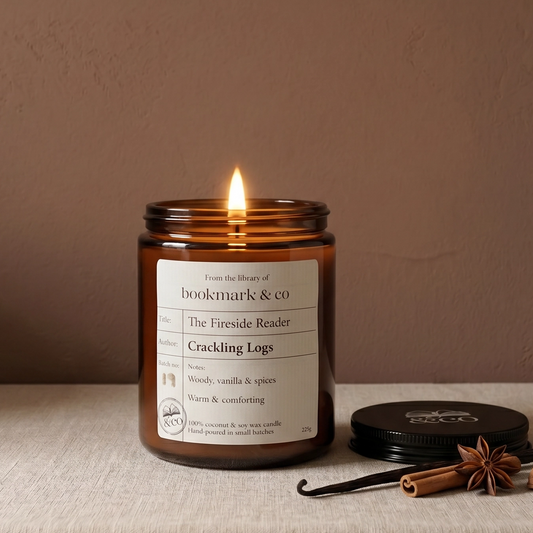 Candle in a glass jar with a label on a textured surface against a plain background