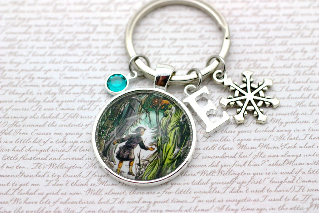 Keychain with a circular charm featuring Lucy and Aslan and a snowflake charm.