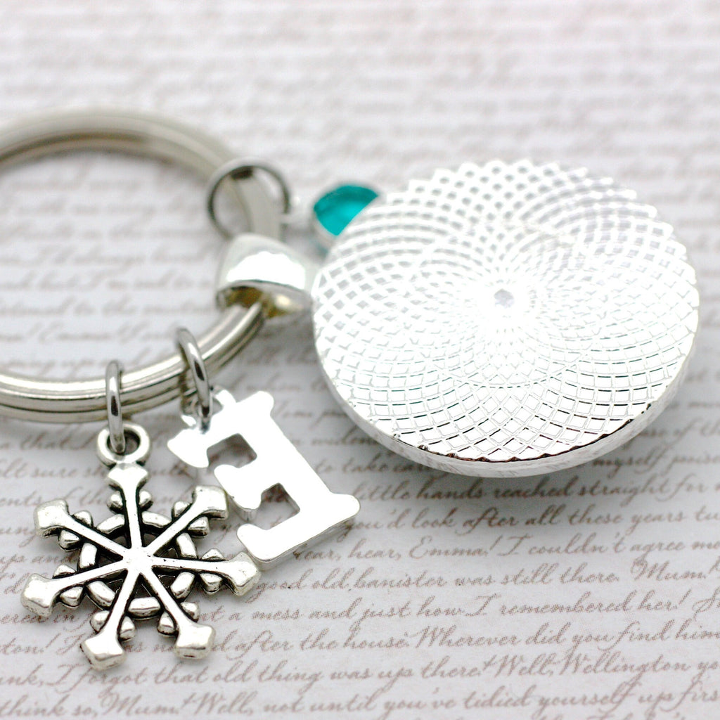 Silver keychain with snowflake charm and round pendant 