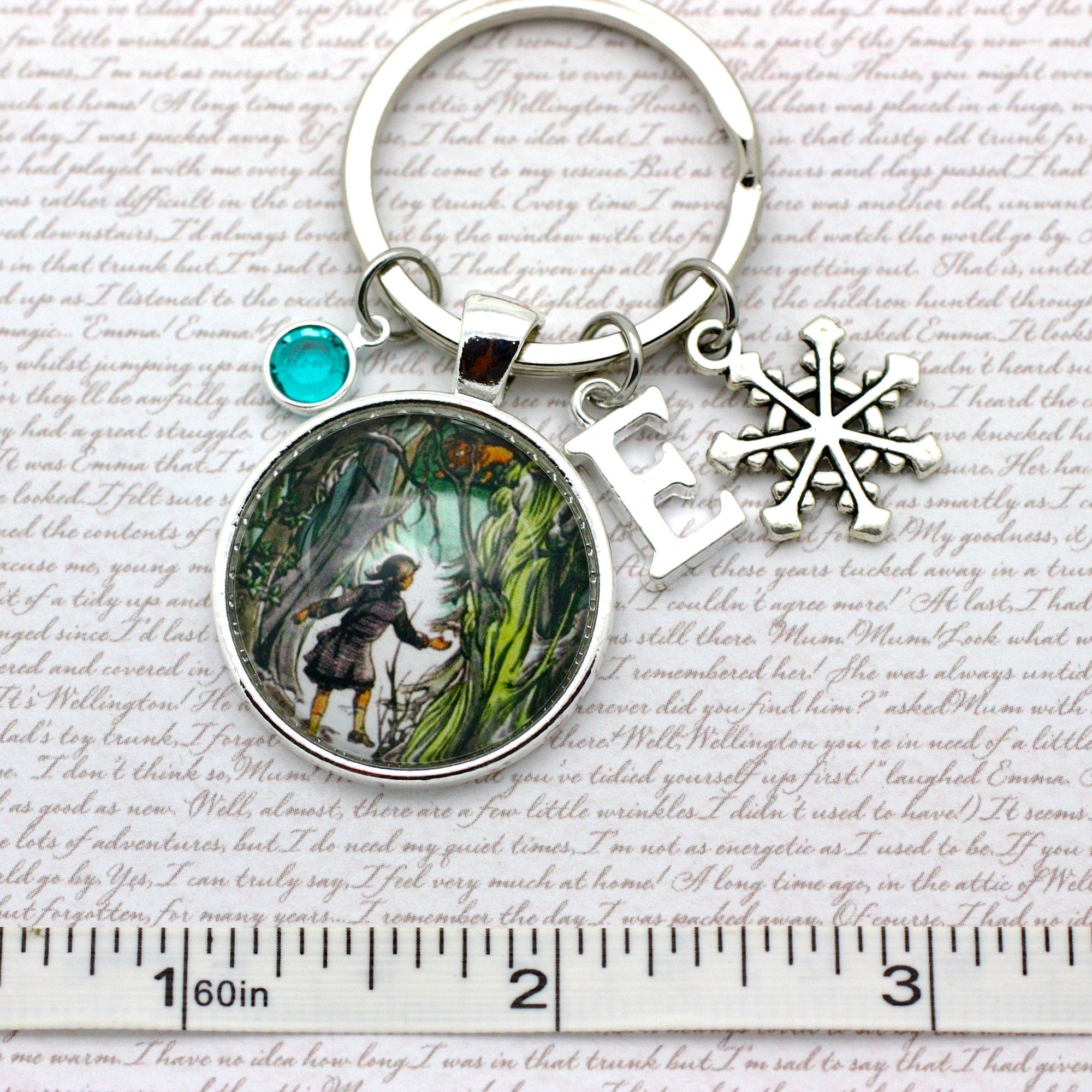 Keychain with a circular pendant featuring an illustration of Lucy and Aslan