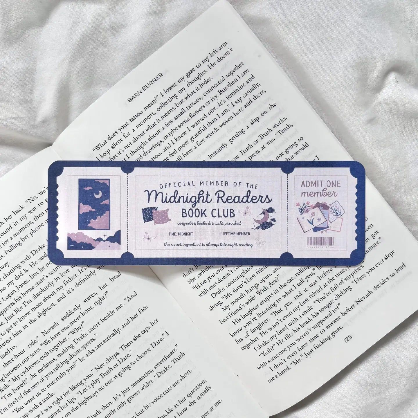 Book with a Midnight Readers Book Club bookmark on a white surface
