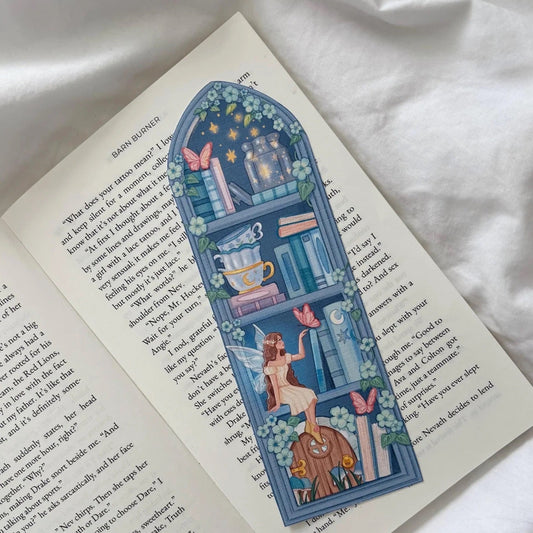 Decorative bookmark with fairy design on an open book