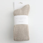 Oatmeal coloured sock with a white label on white background