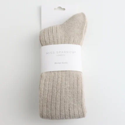 Oatmeal coloured sock with a white label on white background