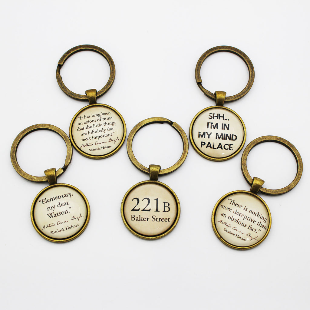 Set of keyrings with Sherlock Holmes quotes on a white background