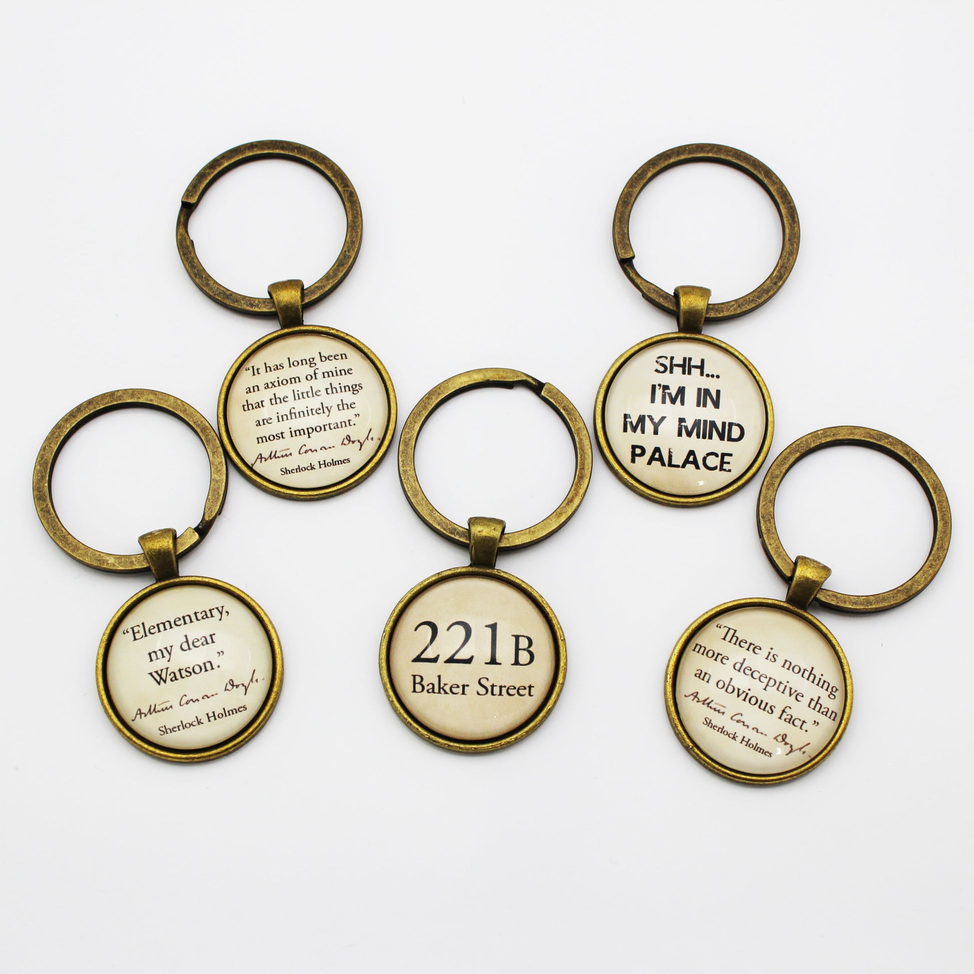 Set of keyrings with Sherlock Holmes quotes on a white background
