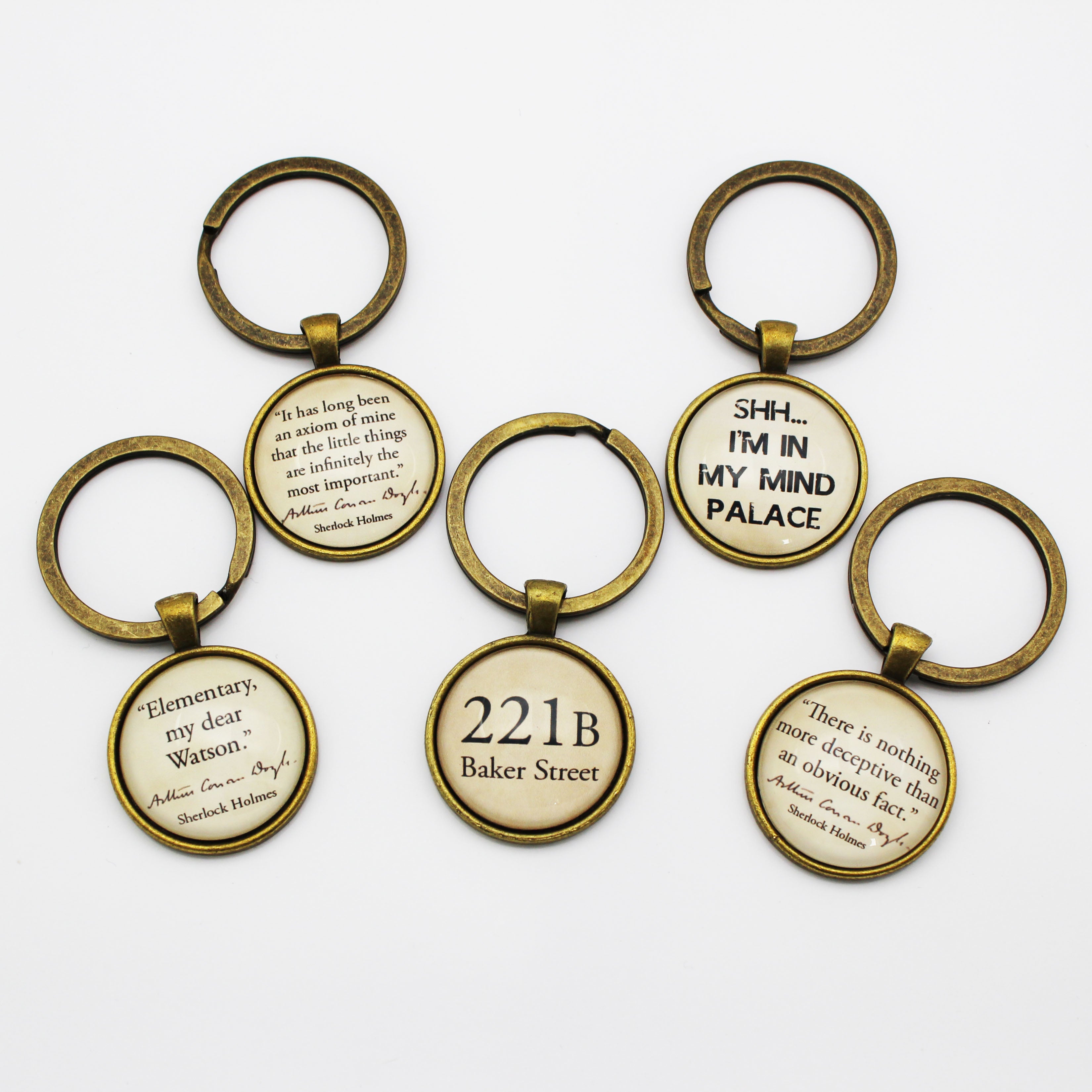 Set of keyrings with Sherlock Holmes quotes on a white background