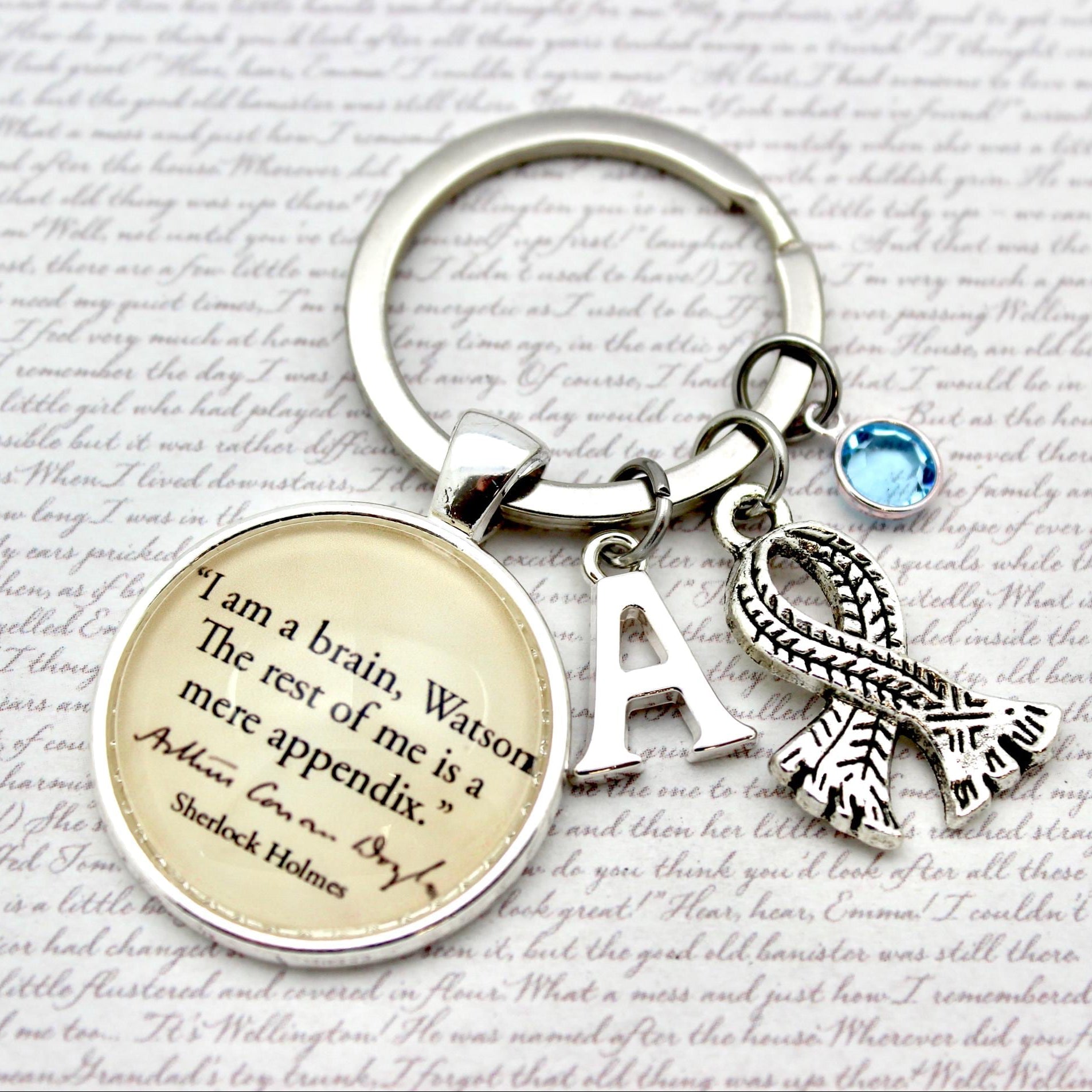 Keychain with sherlock quote and charms on a textured background
