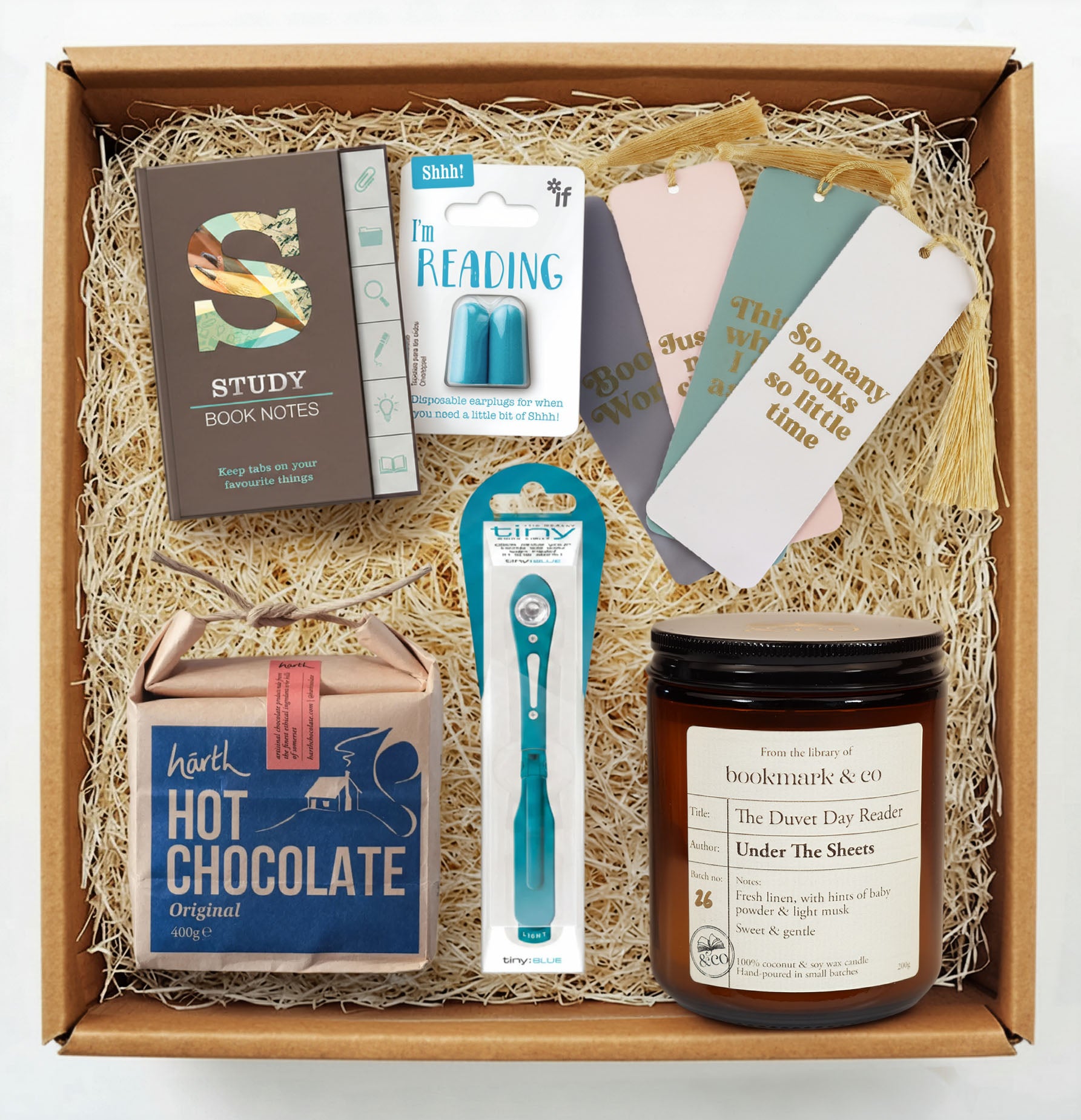 Gift box with study-themed items including a candle, bookmarks, and hot chocolate.