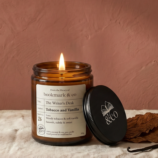 Candle in an amber jar with a label on a textured surface