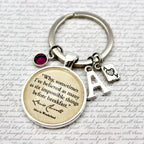 Keychain with a quote charm and letter 'A' charm on a text background