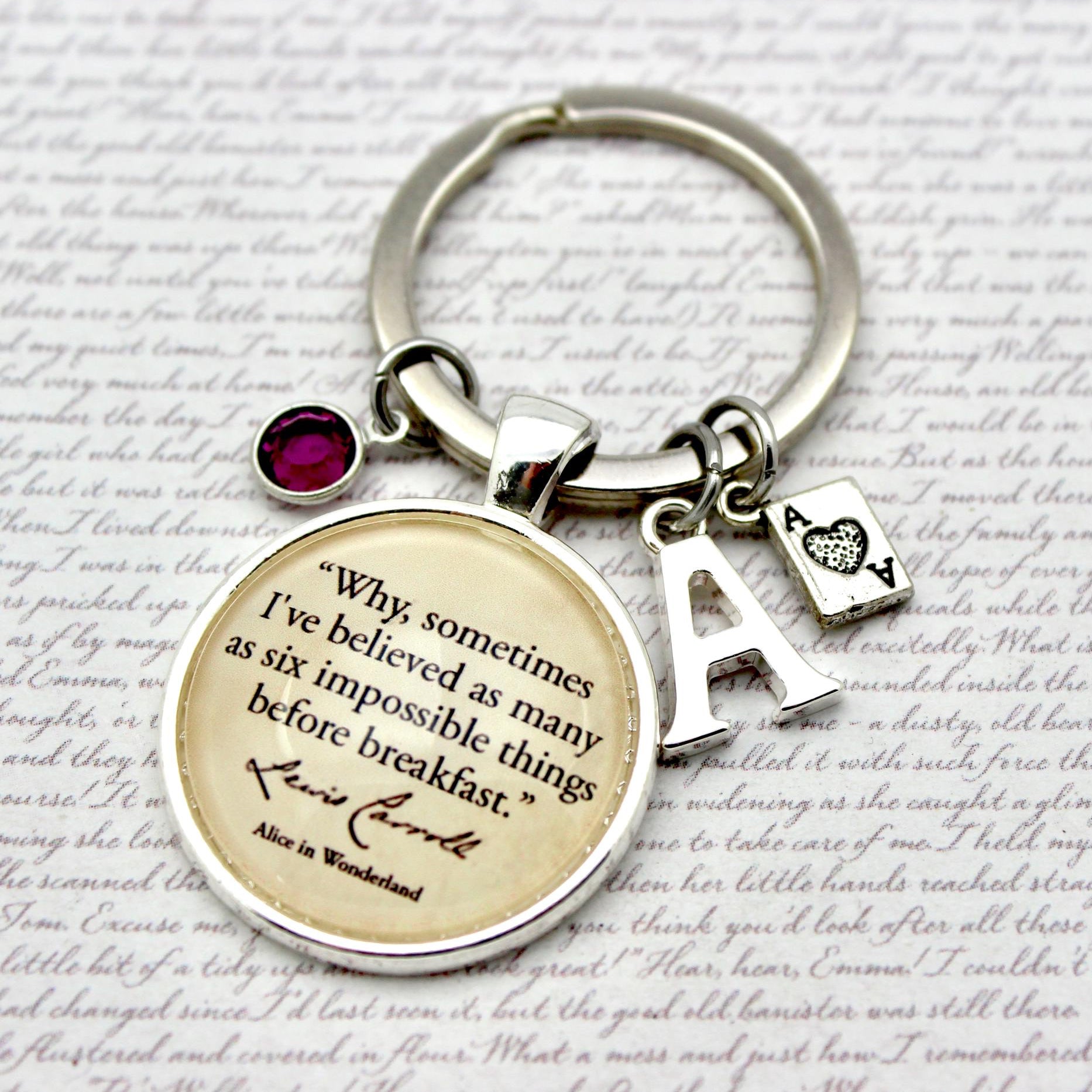 Keychain with a quote charm and letter 'A' charm on a text background