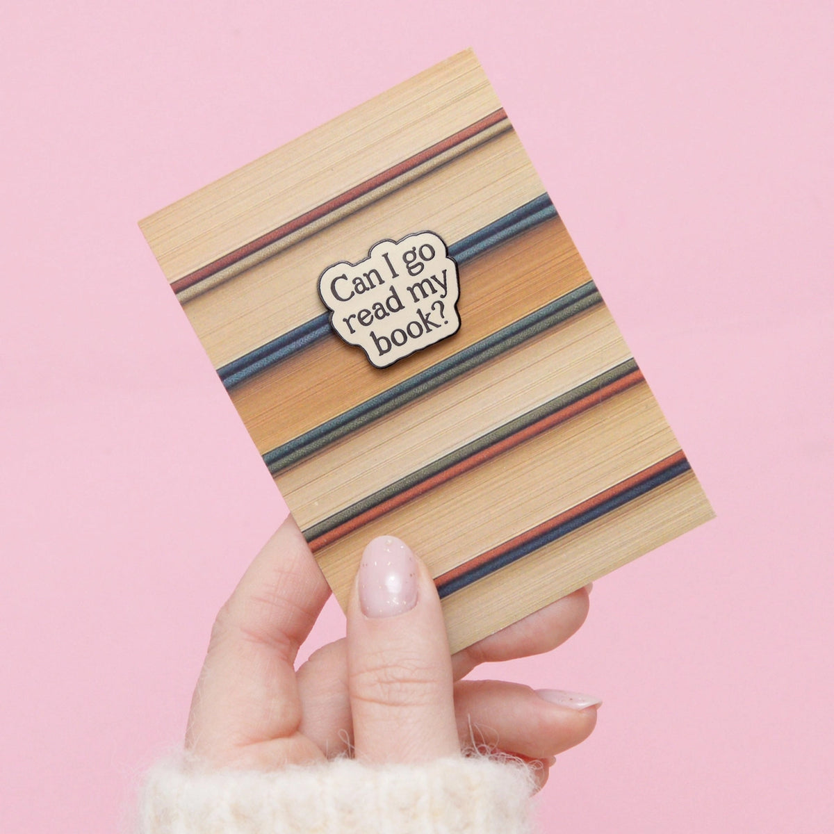 Wooden book-shaped card with striped design and 'Can I go read my book?' message on a pink background.
