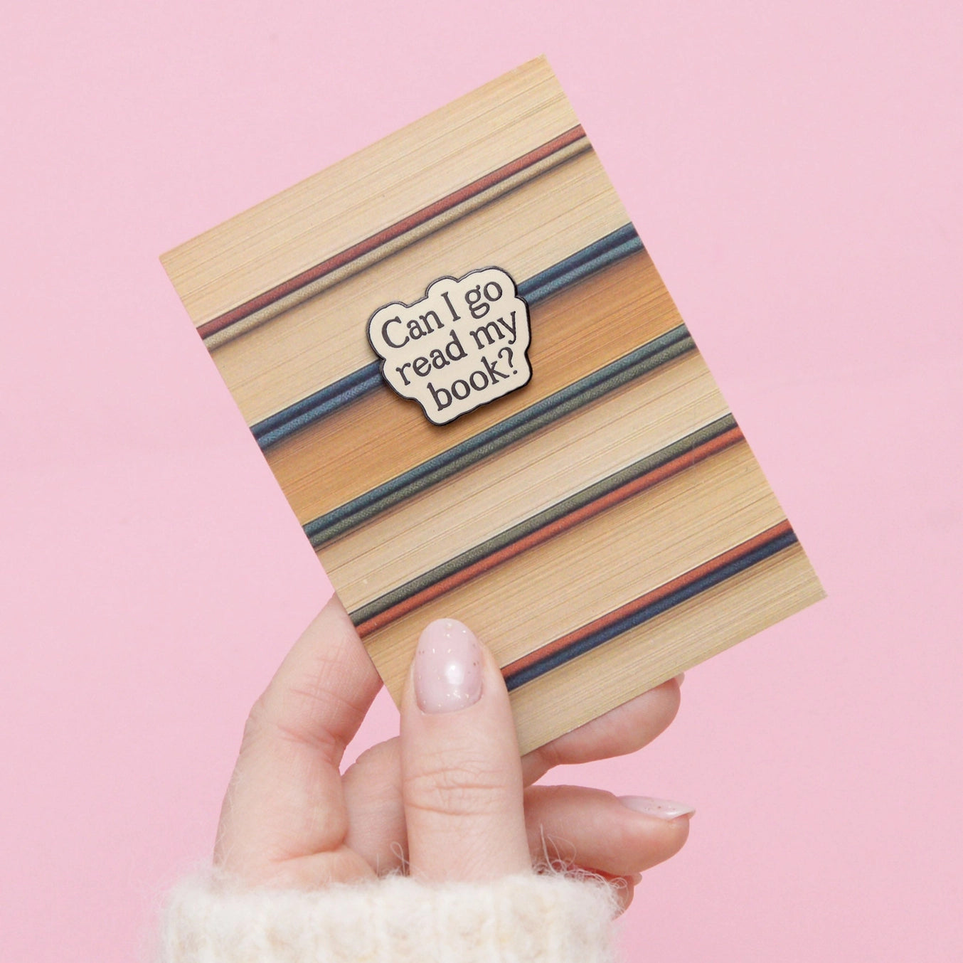 Wooden book-shaped card with striped design and 'Can I go read my book?' message on a pink background.