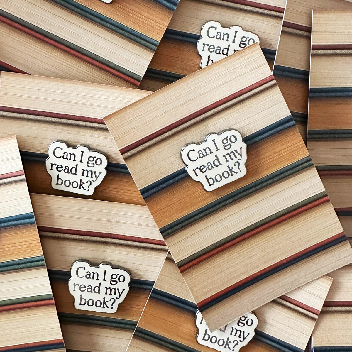 Stack of books with bookmarks that say 'Can I go read my book?'