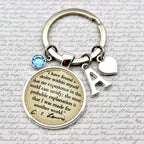 Keychain with circular pendant featuring text and initials on a textured background