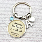 Keychain with 'Courage, dear heart' quote from C.S. Lewis on a textured background