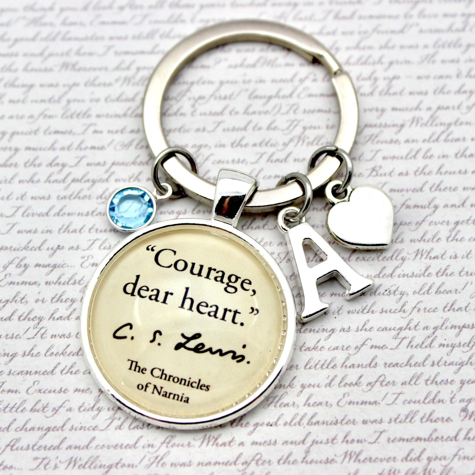 Keychain with 'Courage, dear heart' quote from C.S. Lewis on a textured background