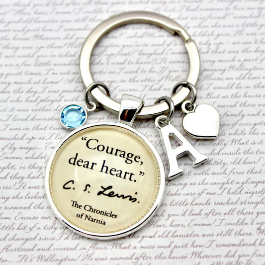 Keychain with 'Courage, dear heart' quote from C.S. Lewis on a textured background