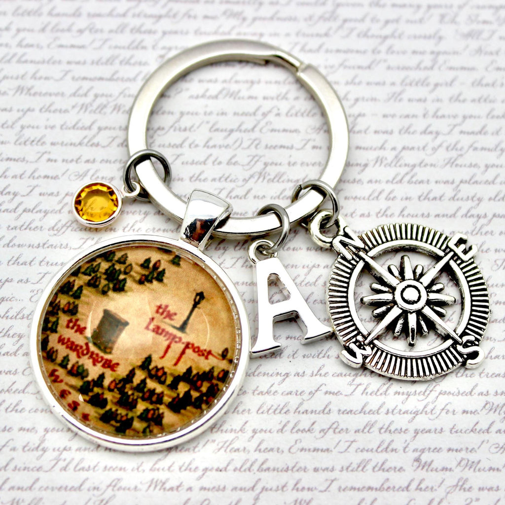 Keychain with compass and circular charm on a textured background