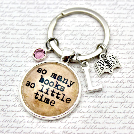 Keychain with 'so many books so little time' charm on a textured background