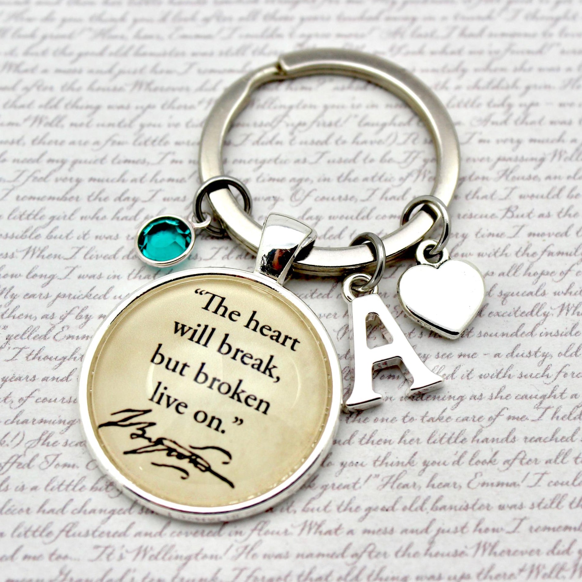 Keychain with motivational quote and letter 'A' charm on a textured background