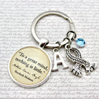 Keychain with inspirational quote, initials, and scarf charm on a script background